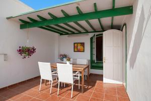 a dining room with a table and white chairs at Apartamento Rocas Negras in Puerto del Carmen