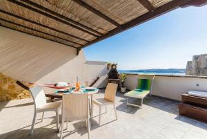a patio with a table and chairs on a balcony at Casa Azzurra a Torre dell'Orso in Torre dell'Orso