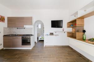 a kitchen with white walls and wooden cabinets at Casa Azzurra a Torre dell'Orso in Torre dell'Orso +21 photos