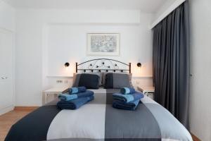 a bedroom with a large bed with blue pillows on it at Club Atlantis with views in Adeje +20 photos