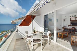 a balcony with a table and chairs and the ocean at Club Atlantis with views in Adeje