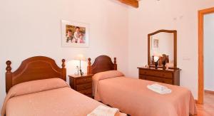 a bedroom with two beds and a mirror at Can Mates Nou in Campos