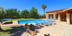 a swimming pool with lounge chairs and a house at Can Mates Nou in Campos
