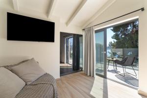 a living room with a couch and a television on a wall at Mella Roa - Villa Onyx in Nydri