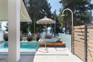 a patio with a chair and an umbrella next to a pool at Mella Roa - Villa Onyx in Nydri