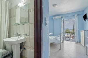 a bathroom with a sink and a mirror and a tub at Giorgio studios-apartments 2 in Nikiana +52 photos
