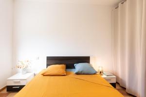 a bedroom with a large yellow bed with two night stands at A Casa Assulanata Cinto in Santa-Reparata-di-Balagna