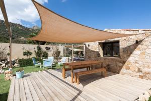 a wooden deck with a wooden bench and a table at A Casa Assulanata Cinto in Santa-Reparata-di-Balagna
