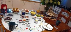a table with food and cups and dishes on it at Chambre - Spa - Piscine - Sauna in Brech