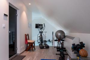 a room with a gym with exercise equipment on the wall at Chambre - Spa - Piscine - Sauna in Brech