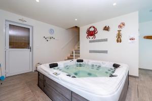 a jacuzzi tub in a room with a staircase at Chambre - Spa - Piscine - Sauna in Brech +17 photos
