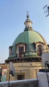 un edificio con una cúpula verde encima en Magic Napoli Red, en Nápoles