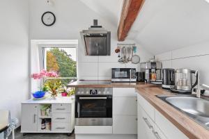 a kitchen with white cabinets and a stove top oven at Ferienwohnung Bailey in Laupheim
