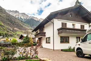 a white house with mountains in the background at Taufner Apartement A 105 in Parcines