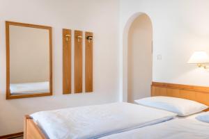 a bedroom with two beds and a mirror at Taufner Apartement A 105 in Parcines