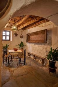 a room with a table and chairs and a stone wall at El Zarzo in Fuenteheridos