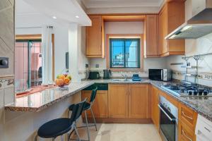 a large kitchen with wooden cabinets and counters at Casa Essência in Armação de Pêra