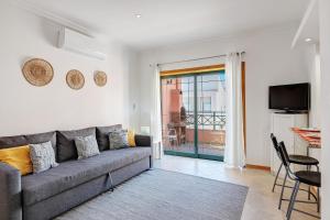 a living room with a gray couch and a table at Casa Essência in Armação de Pêra