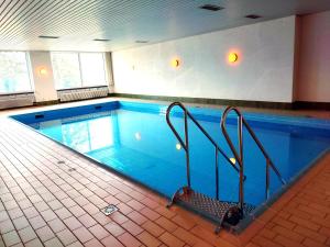 a large swimming pool with blue water in a building at Ferienwohnungen Nordschwarzwald in Freudenstadt
