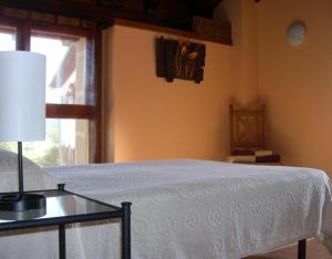 a bedroom with a bed with a table and a window at Bordaberri in Ciáurriz