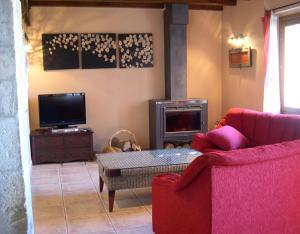 a living room with a red couch and a fire place at Bordaberri in Ciáurriz