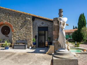 a statue of a woman standing in front of a building at Le Cocon in Villalier