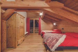 two beds in a room with wooden ceilings at Chalet La Rocca in La Chapelle-dʼAbondance