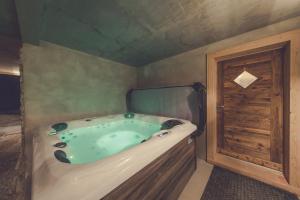 a bath tub in a room with a wooden door at Chalet La Rocca in La Chapelle-dʼAbondance +17 photos