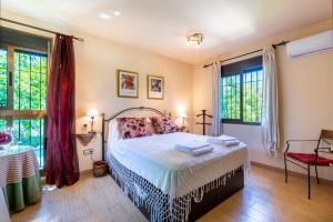a bedroom with a bed and two windows at Villa La bicicleta azul in Málaga +21 photos