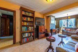 a living room with a couch and book shelves filled with books at Villa La bicicleta azul in Málaga