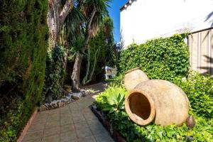 a garden with a bench and plants and a sidewalk at Villa La bicicleta azul in Málaga