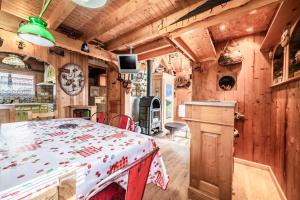 a kitchen and dining room with a table in a cabin at Chalet 6p Classique - L'Erable in Verchaix