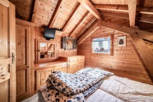 a bedroom in a log cabin with a bed at Chalet 6p Classique - L'Erable in Verchaix