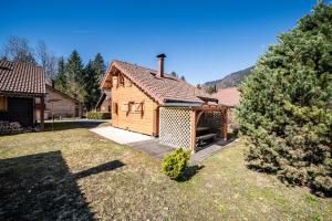 a small wooden cabin with a deck in a yard at Chalet 6p Classique - L'Erable in Verchaix