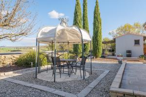 Ein Tisch und Stühle unter einem weißen Sonnenschirm in der Unterkunft Studio 315 in Villeneuve-de-Berg