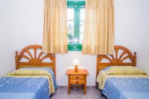 una camera da letto con due letti e una finestra di Apartamentos Sal y Mar a Puerto del Carmen Altre 19 foto