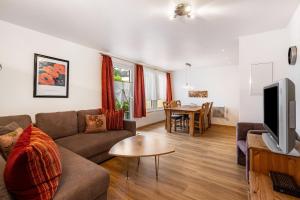 a living room with a couch and a tv and a table at Bungalow 71 in Zeulenroda