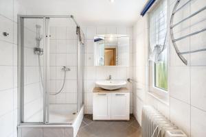 a white bathroom with a sink and a shower at Bungalow 71 in Zeulenroda +16 photos
