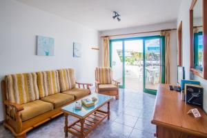 un soggiorno con un divano e un tavolo di Apartamentos Sal y Mar a Puerto del Carmen