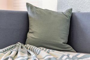 a couch with a pillow and a blanket on it at Ferienwohnung Sterl 13 in Herscheid