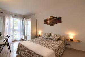 a bedroom with a bed and two lamps and windows at Can Quintaneta in Begur