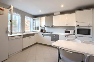 a kitchen with white cabinets and a table and chairs at Can Quintaneta in Begur