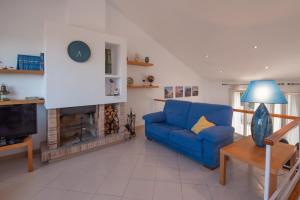 a living room with a blue couch and a fireplace at Can Quintaneta in Begur