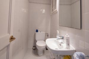 a white bathroom with a toilet and a sink at Can Quintaneta in Begur +26 photos