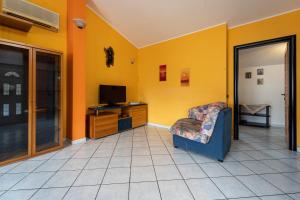 ein Wohnzimmer mit einem Sessel und einem Fernseher in der Unterkunft Casa Flu in Assemini