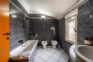 ein Badezimmer mit Badewanne, Toilette und Waschbecken in der Unterkunft Casa Flu in Assemini + 14 Fotos