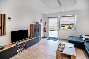 a living room with a couch and a flat screen tv at Ferienwohnung Wittle in Weiler-Simmerberg