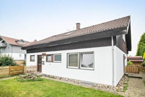 a white house with a black roof at Ferienwohnung Wittle in Weiler-Simmerberg