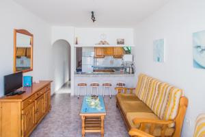 un soggiorno con un divano e un tavolo di Apartamentos Sal y Mar a Puerto del Carmen