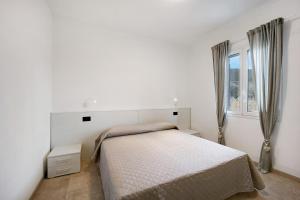 a white bedroom with a bed and a window at Antichi Ricordi - Da Angela in Marina di Andora